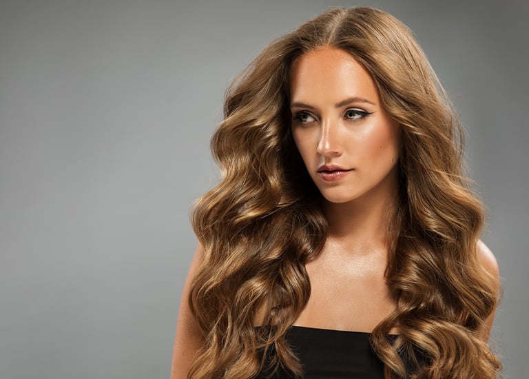 Beautiful girl with long wavy hairstyle over gray background