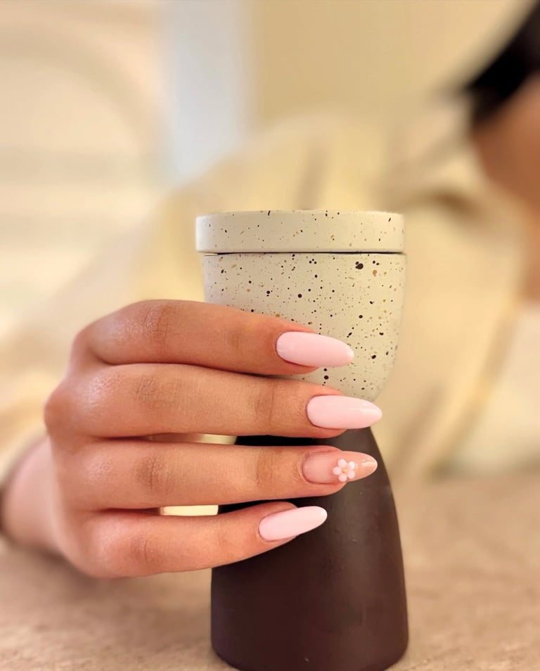 Person holding ceramic cup with manicured nails